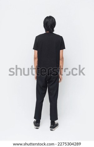 Back full body portrait of young attractive man, wearing black t-shirt pants in studio