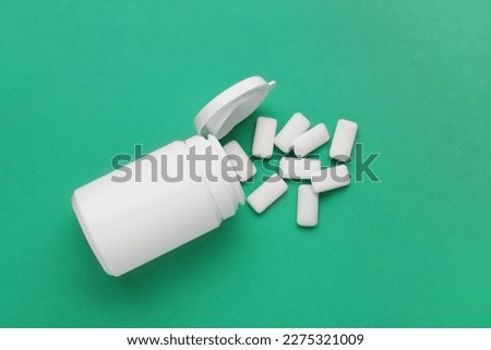Jar with chewing gums on green background, flat lay