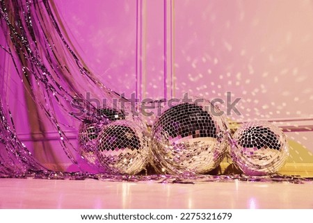 Shiny disco balls and foil fringe curtain indoors, color toned Royalty-Free Stock Photo #2275321679