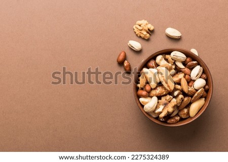 mixed nuts in bowl. Mix of various nuts on colored background. pistachios, cashews, walnuts, hazelnuts, peanuts and brazil nuts. Royalty-Free Stock Photo #2275324389