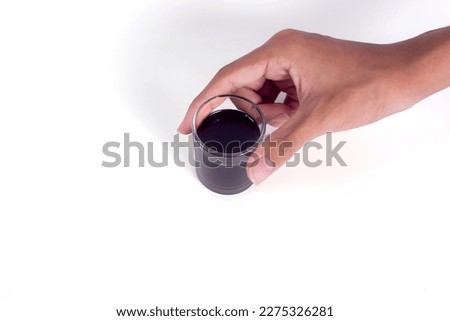 Hand-hold mini glass cup of americano coffee isolated on a white background. Royalty-Free Stock Photo #2275326281