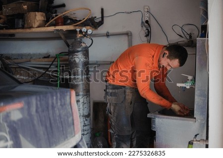 Auto mechanic washing his hands after car repair. Worker washes his hands
