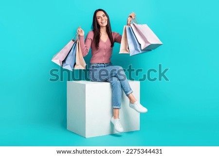Full body cadre of sit white platform girl raise hands up hold much packages with brand clothes shopaholic isolated on aquamarine color background Royalty-Free Stock Photo #2275344431