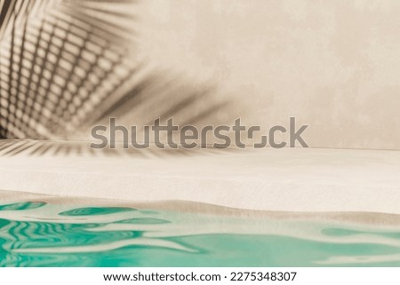 Tropical summer background with concrete wall, pool water and palm leaf shadow. Luxury hotel resort exterior for product placement. Outdoor vacation holiday house scene, neutral architecture aesthetic Royalty-Free Stock Photo #2275348307