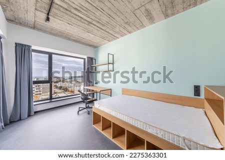 Simple student-style dorm bedroom. Hostel dormitory room. Campus Royalty-Free Stock Photo #2275363301