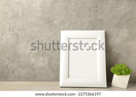 Interior design with white mock up photo frame on grey background with beautiful plants. Top view