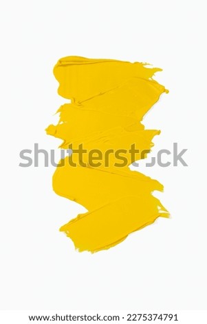 Smear and texture of acrylic paint isolated on white background. Cream texture. Bright yellow color paint product brush stroke swipe sample