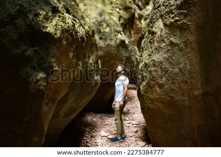 Cave exploration, exploring a cavern. Young woman explorer walks through a narrow path in caves and caverns in Estrecho de la Arboleja or Agualeja in Murcia, Spain. Royalty-Free Stock Photo #2275384777