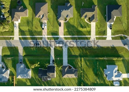 Aerial view of street traffic with driving cars in small town. American suburban landscape with private homes between green palm trees in Florida quiet residential area Royalty-Free Stock Photo #2275384809