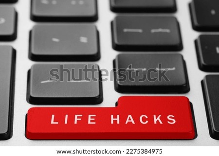 Red button with words Life Hacks on laptop, closeup
