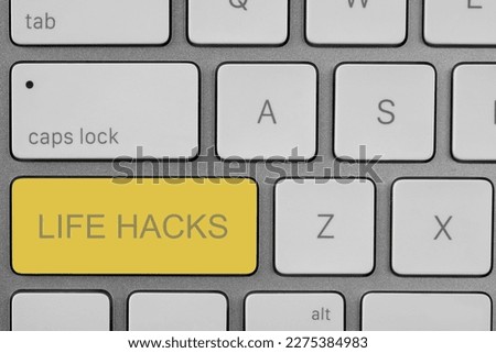 Yellow button with words Life Hacks on laptop, top view