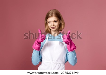woman in rubber gloves and cleaner apron showing ok sign