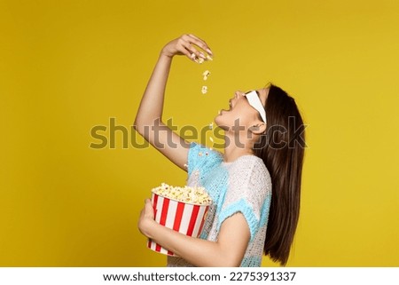beautiful caucasian woman in 3d glasses eating popcorn
