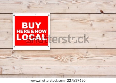 BUY LOCAL HERE AND NOW Sign Red White Sign on Timber Wall Background