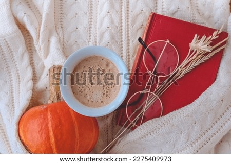 Autumn still life with a cup of hot chocolate, pumpkins, knitted blanket and autumn leaves on a white background Royalty-Free Stock Photo #2275409973