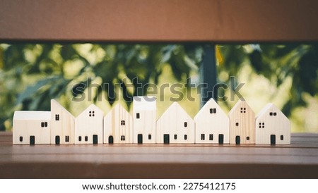 Wooden house model on wood background, a symbol for construction, ecology, loan, mortgage, property or home.