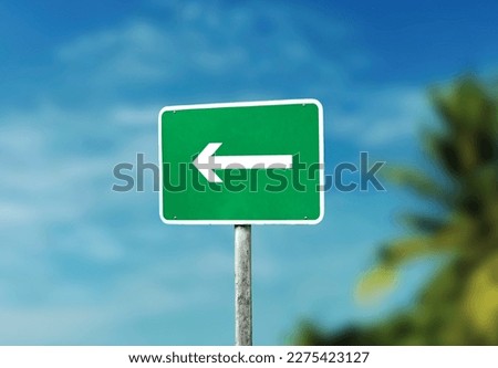 blank green directional arrow sign isolated on blue sky background