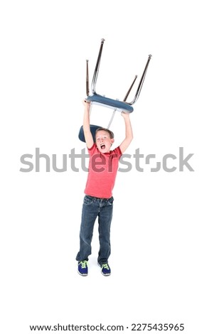 Wild Boy holding a chair over his head while yelling Royalty-Free Stock Photo #2275435965