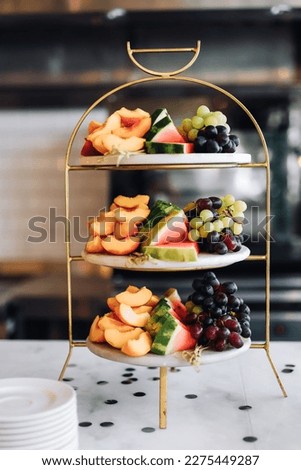 Assorted fruits on three-tiered cake stand Royalty-Free Stock Photo #2275449287