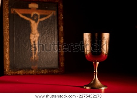 christian chalice on altar  crucified jesus christ picture with strong red background