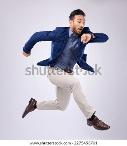 Wristwatch, jump and Asian man late, appointment and employee against a grey studio background. Male manager, consultant and employee with schedule, deadline and stress with clock, jump and movement Royalty-Free Stock Photo #2275453701