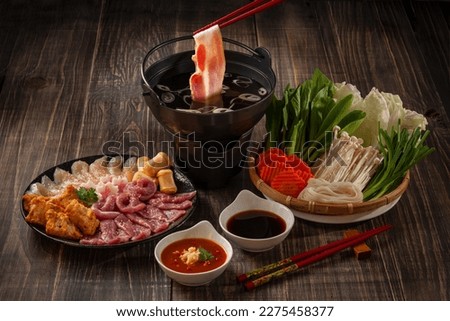 Shabu-shabu or Sukiyaki. Beef slice on top of hot pot, Fresh beef slices with ingredients background for Japanese shabu-shabu or Sukiyaki. Royalty-Free Stock Photo #2275458377