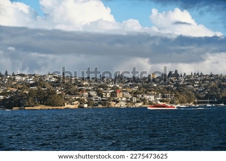 Waterfront housing on the harborside of the Vaucluse suburb featuring Parsley bay -right- with its suspension footbridge and Macquarie lighthouse -left- atop the hillside. Sydney Harbour-NSW-Australia Royalty-Free Stock Photo #2275473625