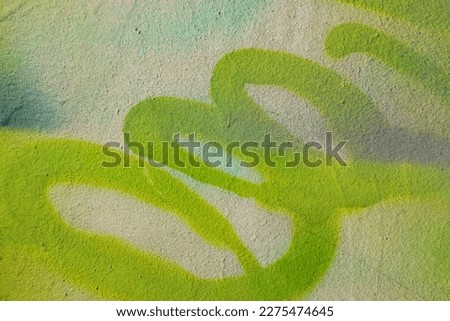 Fragment of old plaster wall with graffiti painting. Part of colorful street art graffiti on wall background. Youth, urban culture. Yellow, green colors