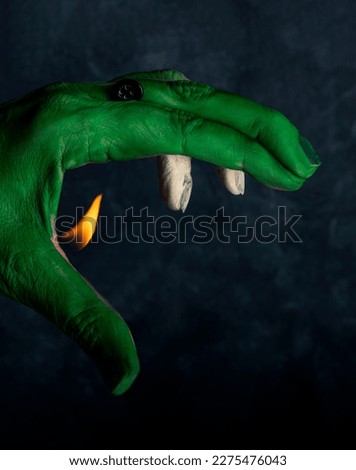 Hand painted green and white, with a flame coming out and a button, simulating a fire-breathing dragon