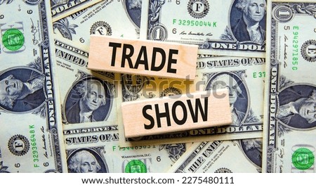 Trade show symbol. Wooden blocks with concept words Trade show on beautiful background from dollar bills. Business economic financial trade show concept. Copy space.