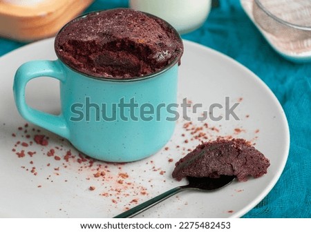 Quick Homemade Chocolate Microwave Mug Brownie Ready to Eat. Chocolate biscuit cake in a blue ceramic mug. Easy cooking concept, microwave baking. muffin chocolate. High quality photo Royalty-Free Stock Photo #2275482453