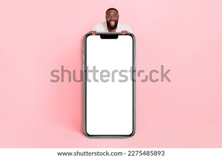 Photo of excited funky young man wear white shirt holding modern device empty space isolated pink color background