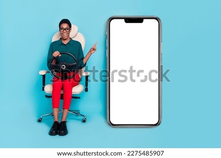 Photo of excited funny trans person dressed green shirt driving auto pointing modern gadget empty space isolated blue color background