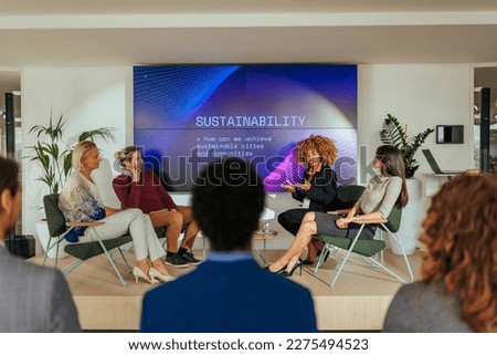 A renewable energy source discussion panel is going on in a business conference with people in audience listening to diverse expert speakers on the stage. Royalty-Free Stock Photo #2275494523