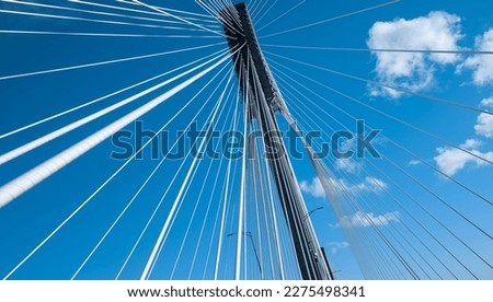 Modern bridge pylon against a blue sky. Detail of the multi-span cable-stayed bridge. Linear perspective view of a white cable-stayed suspension Alex Fraiser Bridge in BC. Nobody, selective focus Royalty-Free Stock Photo #2275498341