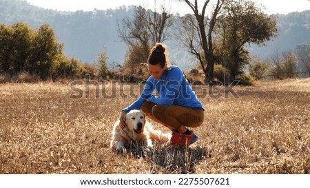 Spanish woman petting her pet in a meadow