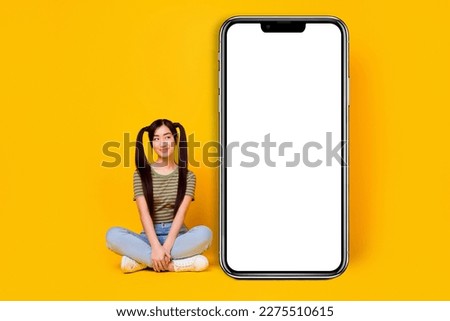 Picture of pretty girl look at big long smartphone advertising board isolated on yellow color background