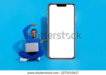 Photo of funny sweet woman wear sweatshirt writing pointing modern device empty space isolated blue color background