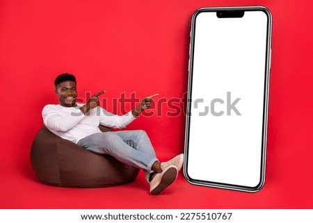 Photo of positive pretty guy wear white shirt pointing modern device empty space isolated red color background