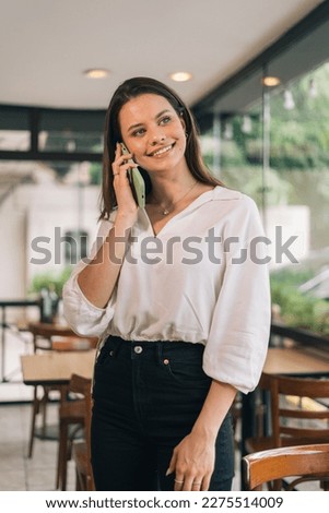 Concept of smiling woman making calls with a telephone in her office. Vertical photo of a person taking order on the phone Royalty-Free Stock Photo #2275514009