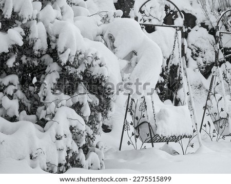 Snow-covered metal swing in a park