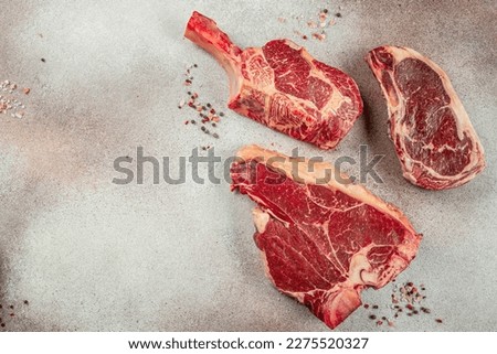 Variety of Raw Black Angus Prime meat steaks T-bone, tomahawk, New York steak. Set raw marbled beef strip loin steaks. place for text, top view. Royalty-Free Stock Photo #2275520327