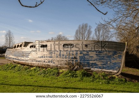 Derelict boat near river Great Ouse at Needingworth, Saint Ivres, Cambridgeshire, England. Royalty-Free Stock Photo #2275526067