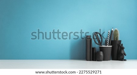 Home office desk with black supplies, Easter bunny and blue wall background
