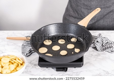 Frying mini pancake cereal in a nonstick frying pan. Royalty-Free Stock Photo #2275532459