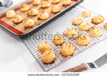 Cooling freshly baked coconut cookies on the kitchen drying rack. Royalty-Free Stock Photo #2275532509