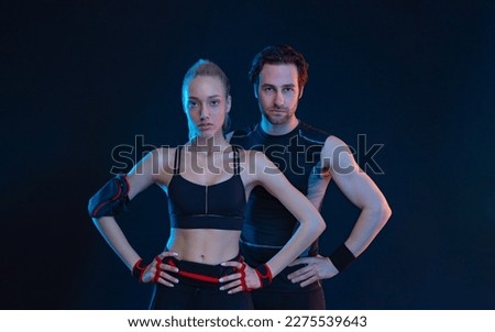 Fit couple at the gym isolated on black background. Fitness concept. Healthy life style. Sports wallpaper for sports advertising. Picture for a sports article in a magazine, website.