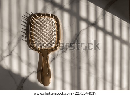 Golden hairbrush with falls out hair Royalty-Free Stock Photo #2275544019