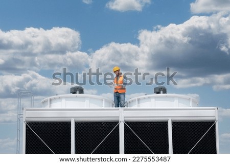 Industry engineer under checking the industry cooling tower air conditioner is water cooling tower air chiller HVAC of large industrial building to control air system. Royalty-Free Stock Photo #2275553487