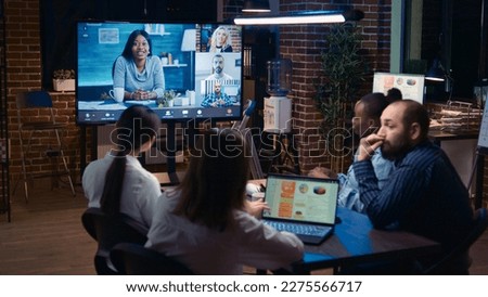 Remote team discussing analytics report in business meeting videocall, diverse employees talking in videoconference at night time. Office workers chatting in teleconference, brainstorming Royalty-Free Stock Photo #2275566717